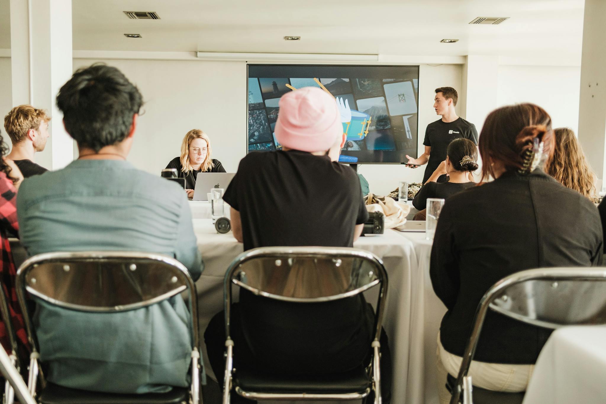 A diverse team in a modern office setting, collaborating during a meeting with a presentation.